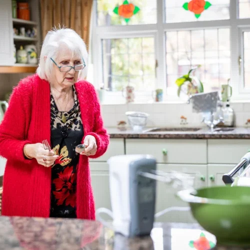 mujer de edad avanazada cocinando