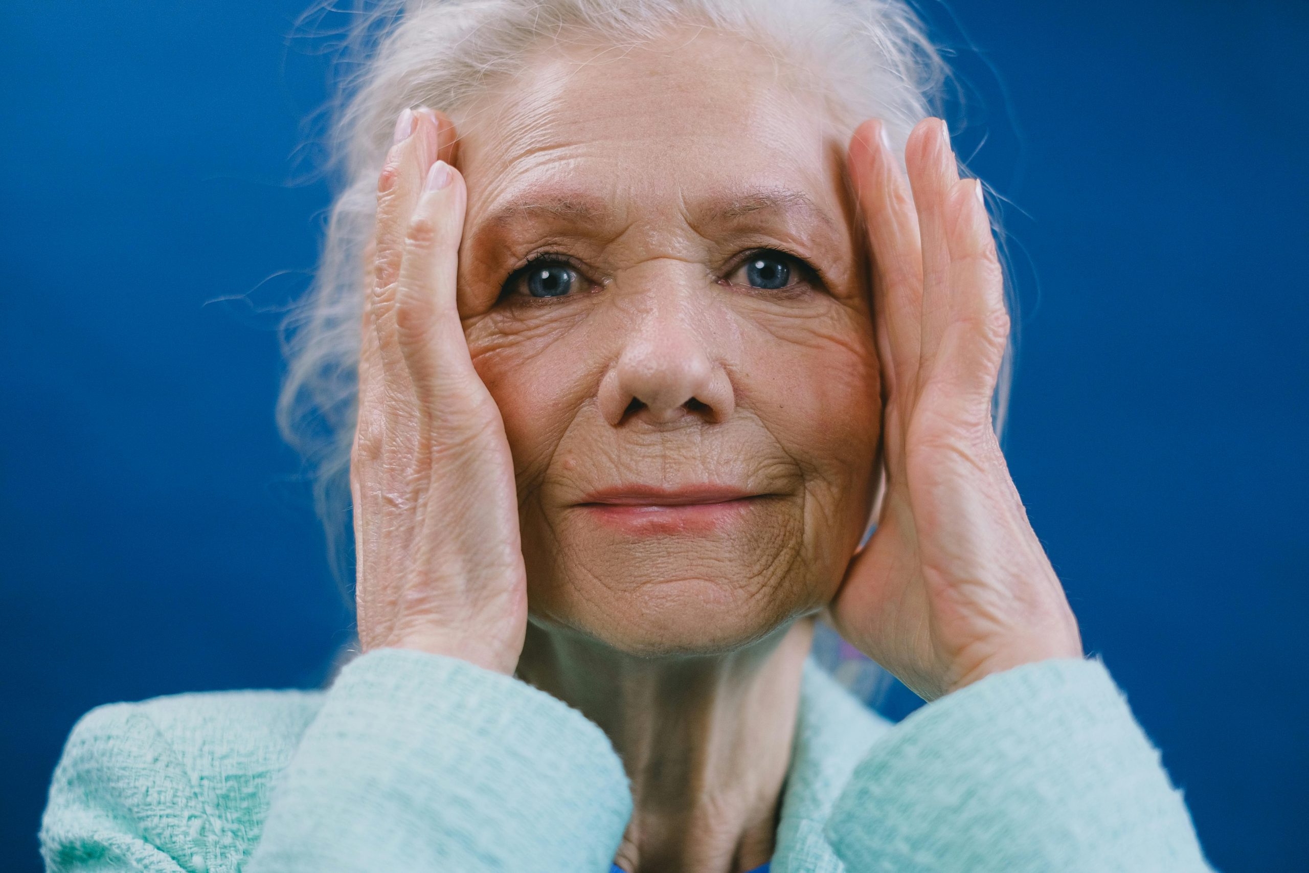 mujer de edad avanzada con las manos en la cabeza y expresión de confusión