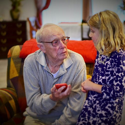 hombre en suéter gris sentado al lado de una mujer en camisa de manga larga floral blanca y negra